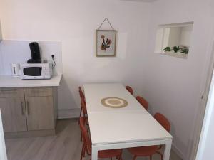 a kitchen with a white table and a microwave at Spacieux T3 Hypercentre Proche Cathédrale in Albi