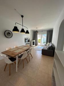 ein Wohnzimmer mit einem Tisch, Stühlen und einem Sofa in der Unterkunft Casa Feliz in Beniarbeig