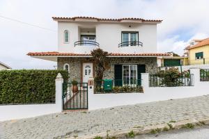 une maison blanche avec une porte sur une rue pavée dans l'établissement Spacious 3 bedroom house w/ swimming pool, à Ericeira