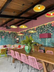 una sala da pranzo con un grande tavolo in legno e sedie rosa di El Jardin de Gala a Castejón de Monegros