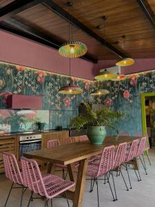 a dining room with a wooden table and pink chairs at El Jardin de Gala in Castejón de Monegros