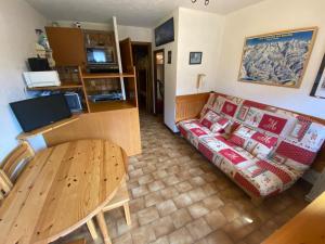 a living room with a couch and a table at Chaleureux studio avec balcon Sud/Ouest à 500m du centre, parking et à deux pas des remontées! - FR-1-693-54 in Châtel