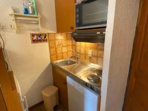 a small kitchen with a sink and a microwave at Chaleureux studio avec balcon Sud/Ouest à 500m du centre, parking et à deux pas des remontées! - FR-1-693-54 in Châtel +6 photos
