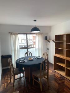 uma sala de jantar com uma mesa e cadeiras e uma janela em Departamento 100% equipado y excelente ubicación em Córdoba
