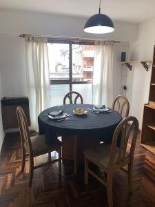 uma mesa de jantar e cadeiras com uma mesa azul e uma janela em Departamento 100% equipado y excelente ubicación em Córdoba