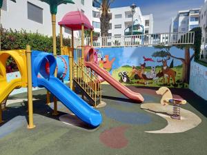 Appartement la Siesta beach resort Mohammedia في المحمدية: ملعب مع زحليقة في حديقة