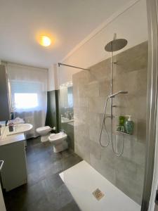 y baño con ducha, 2 lavabos y aseo. en Appartamento Trento Centro, en Trento