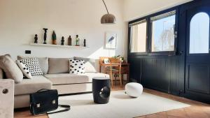 un soggiorno con divano e porta nera di Panoramico10 Apartment with a view in Valpolicella a SantʼAmbrogio di Valpolicella