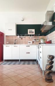 una cucina con armadi bianchi e parete verde di Panoramico10 Apartment with a view in Valpolicella a SantʼAmbrogio di Valpolicella