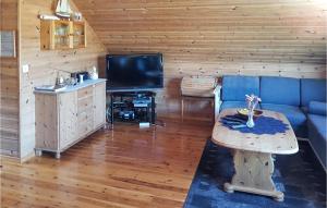 a living room with a blue couch and a tv at Holiday Home Finnås Lyklingsjøvegen in Lykling