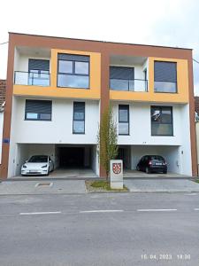 un edificio con dos coches estacionados en un estacionamiento en Tesla Point en Osijek