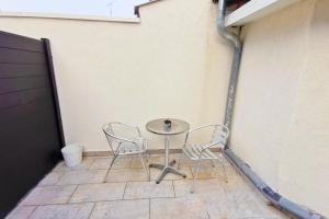stół i 2 krzesła na patio w obiekcie Studio design tout équipé avec netflix & terrasse w mieście Bourg-en-Bresse