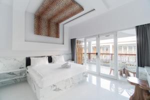 Habitación blanca con cama y balcón. en Sea Shell Resort, en Gili Trawangan