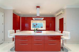 uma cozinha vermelha com um balcão branco e armários vermelhos em Casa Nua em Puerto del Carmen