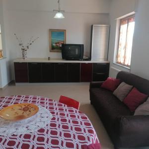 ein Wohnzimmer mit einem Sofa und einem Tisch in der Unterkunft Appartamenti & Camere TRA SCILLA e TROPEA in San Ferdinando