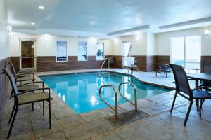 a pool in a hotel room with chairs and a table at Fairfield Inn and Suites San Bernardino in San Bernardino