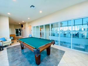 a pool table in a room with glass walls at Crystal Shores 1301 by ALBVR - Beautiful Beachfront Corner Condo with Gorgeous Views! in Gulf Shores