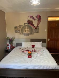 a bed with a bunch of red rose petals on it at Riambel Paradise Inn Luxury Room in Riambel