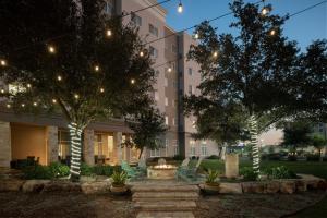 a courtyard with a fire pit in front of a building at Residence Inn by Marriott San Antonio Six Flags at The RIM in San Antonio