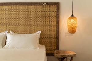 a bedroom with a bed with a wooden headboard and a table at Manta Reserve in Maalhos