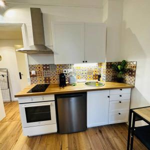 a kitchen with white cabinets and a wooden floor at A2D Bel appartement, Nancy Thermal in Nancy