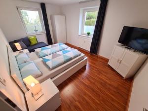 a small room with a bed and a television at Ferienwohnung Steigerwald Gerolzhofen in Gerolzhofen