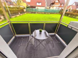 a balcony with a white table and a green field at Ferienwohnung Steigerwald Gerolzhofen in Gerolzhofen