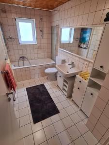 a bathroom with a tub and a sink and a toilet at Ferienwohnung Steigerwald Gerolzhofen in Gerolzhofen