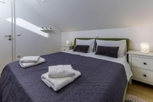 a bedroom with a large bed with towels on it at Apartman Merita in Dubrovnik