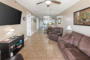 a living room with a couch and a flat screen tv at Island Royale 1002 by ALBVR - Come & relax at our beautiful beachfront condo in the heart of Gulf Shores! in Gulf Shores