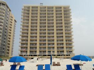 a large building on the beach with chairs and umbrellas at Island Royale 1002 by ALBVR - Come & relax at our beautiful beachfront condo in the heart of Gulf Shores! in Gulf Shores