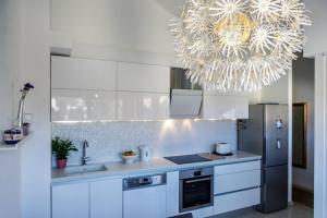 a kitchen with white cabinets and a large chandelier at Apartman Merita in Dubrovnik