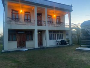 una casa blanca con una escalera delante en Luka Family Guest House en Batumi