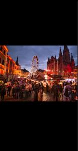 een menigte mensen die 's nachts in een stad staan bij Sweet Home in Mulhouse