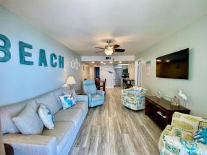 sala de estar con sofá y TV en Phoenix I 1117 by ALBVR - Beachfront and beautifully-updated - The perfect spot to vaca with amazing views!, en Orange Beach