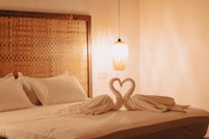 two swans making a heart on a bed at Manta Reserve in Maalhos