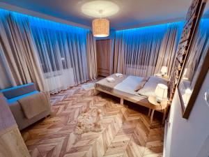 Bańska NiżnaにあるVilla Bańskaのベッドルーム1室(ベッド1台、ソファ、青いカーテン付)