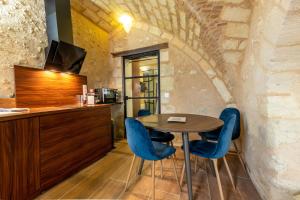 a kitchen with a table and blue chairs at Les pieds dans le Château - Jacuzzi in Amboise