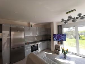 a kitchen with stainless steel appliances and a couch at Mama Fox in Alepou