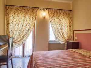 a bedroom with a bed and a window with curtains at Eremo dei Poeti in Aulla