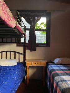 a bedroom with two bunk beds and a window at Casa Qatzij - Guest House, Lake Atitlan in San Lucas Tolimán