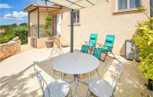 Un patio con una mesa y sillas blancas. en Beautiful Home In Barjac With Wifi, en Barjac