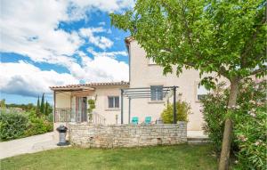 a house with a stone wall and a tree at Beautiful Home In Barjac With Swimming Pool in Barjac