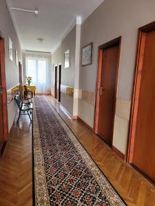 pasillo con alfombra en el suelo y puertas de madera en Zajazd Meran en Krynica Zdrój