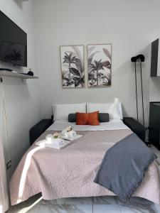 een slaapkamer met een groot bed met twee foto's aan de muur bij La casa di Ale 69 in Napels