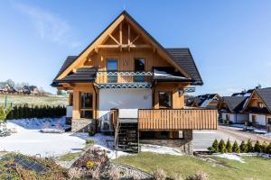 a wooden house with a gambrel roof at Apartament Czorsztyn in Kluszkowce