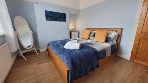 a bedroom with a large bed with a blue blanket at Colenso St - 2 bed house by Bishy Road & River in York
