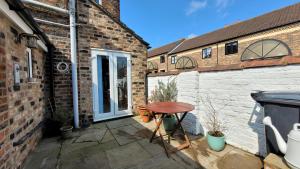 a small table sitting on a patio outside a building at Colenso St - 2 bed house by Bishy Road & River in York