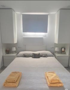 a bedroom with a bed with two towels on it at Vamos a la playa ! in Es Pujols