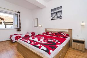 a bedroom with two beds with red and white blankets at Romantic studio apartment in Sobra